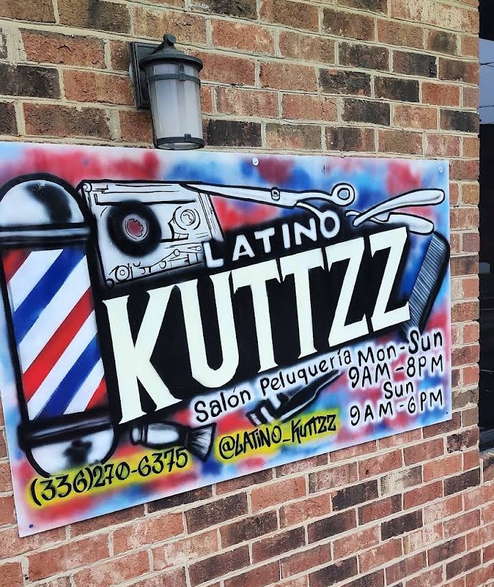 Hand-painted Latino Kuttzz shop sign with barber pole, razor and shop hours